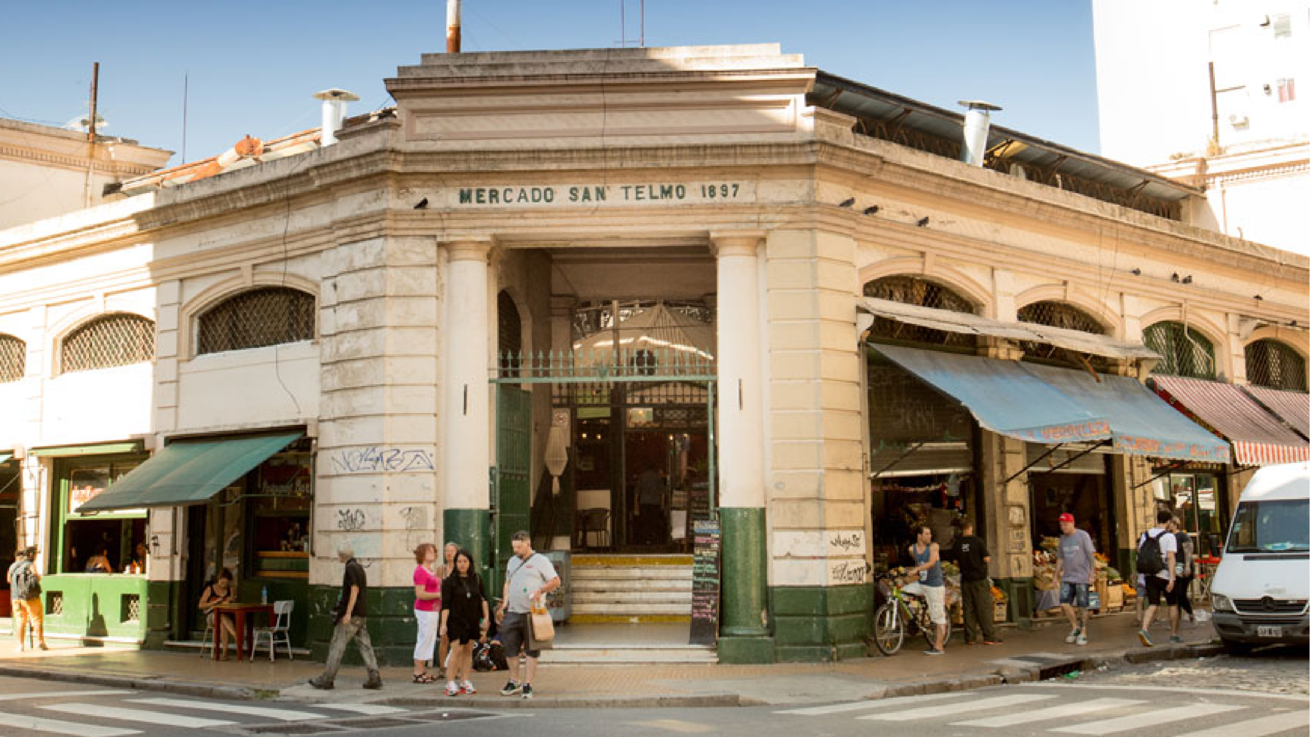 Corner facade of the Mercado de San Telmo with its 1897 lintel and green ironwork