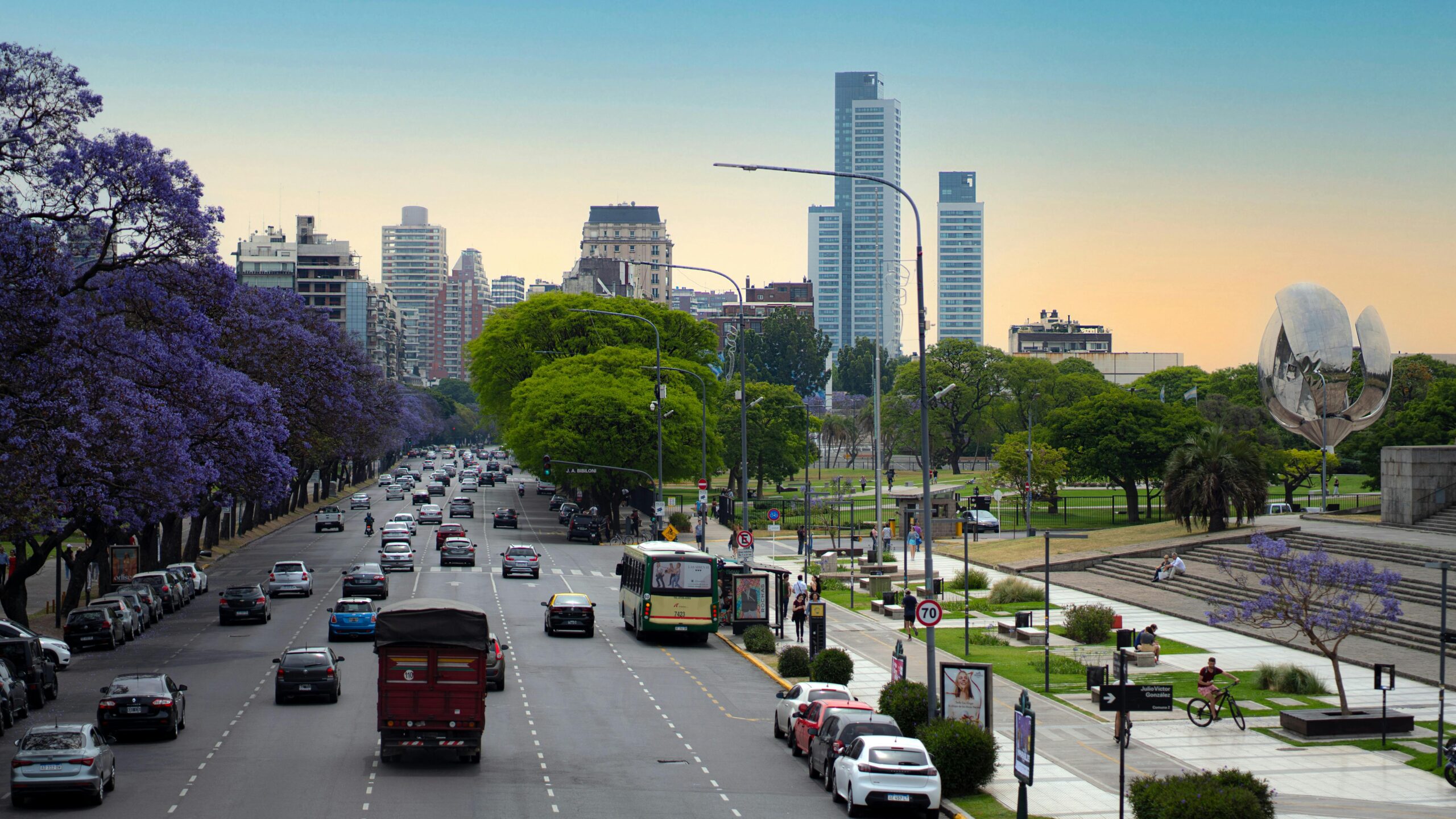 Jacarandas in bloom along Avenida Figueroa Alcorta in Recoleta, the Floralis Generica at right