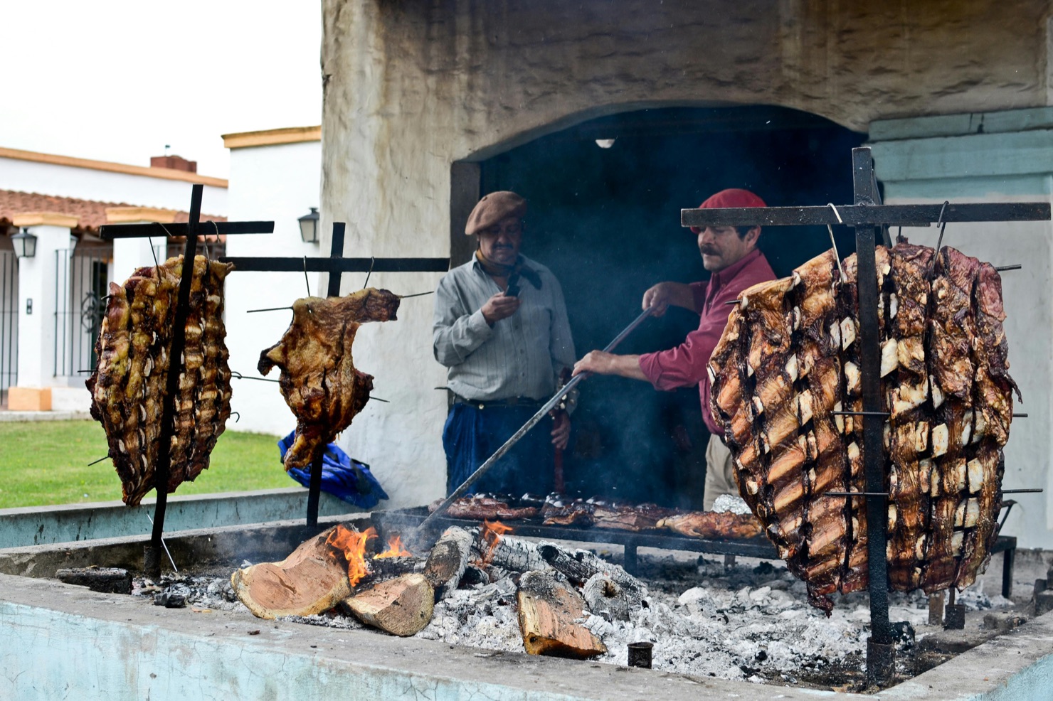 Argentine asado slow cooked on iron crosses over an open fire near Buenos Aires
