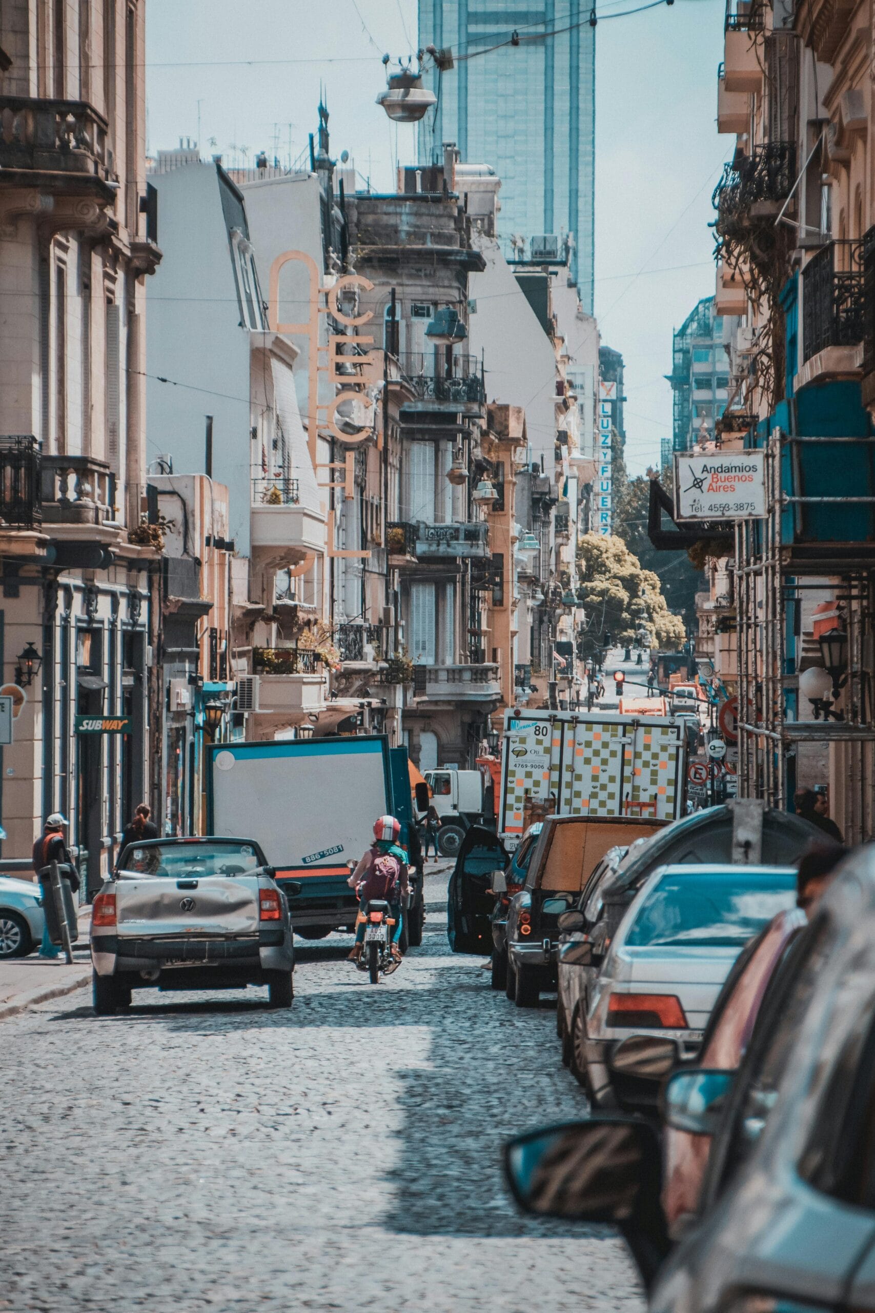 A cobblestone street in San Telmo with old buildings and a person walking