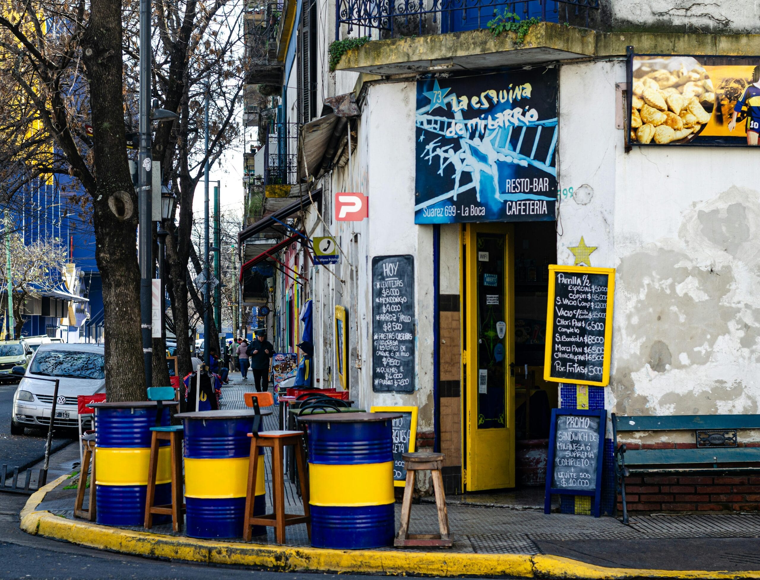 A corner bar with painted tables and stools out on the pavement in Buenos Aires